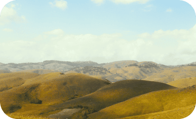 Scenic view of rolling hills under a partly cloudy sky.