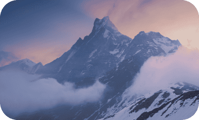 Majestic snow-capped mountain peak at sunrise with clouds.