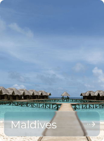 Overwater bungalows in the Maldives with clear blue sky and turquoise water.