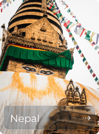 Ancient Buddhist stupa in Nepal with prayer flags and decorative elements.